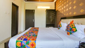 Habitación de hotel con una cama grande, cabecera con diseño estampado y puerta con motivo geométrico.