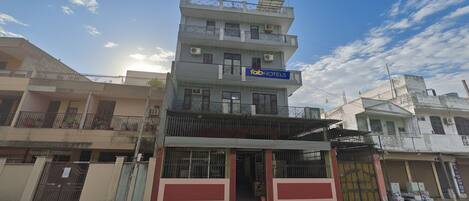 A multi-story building with a sign for 'Fab Hotels'.