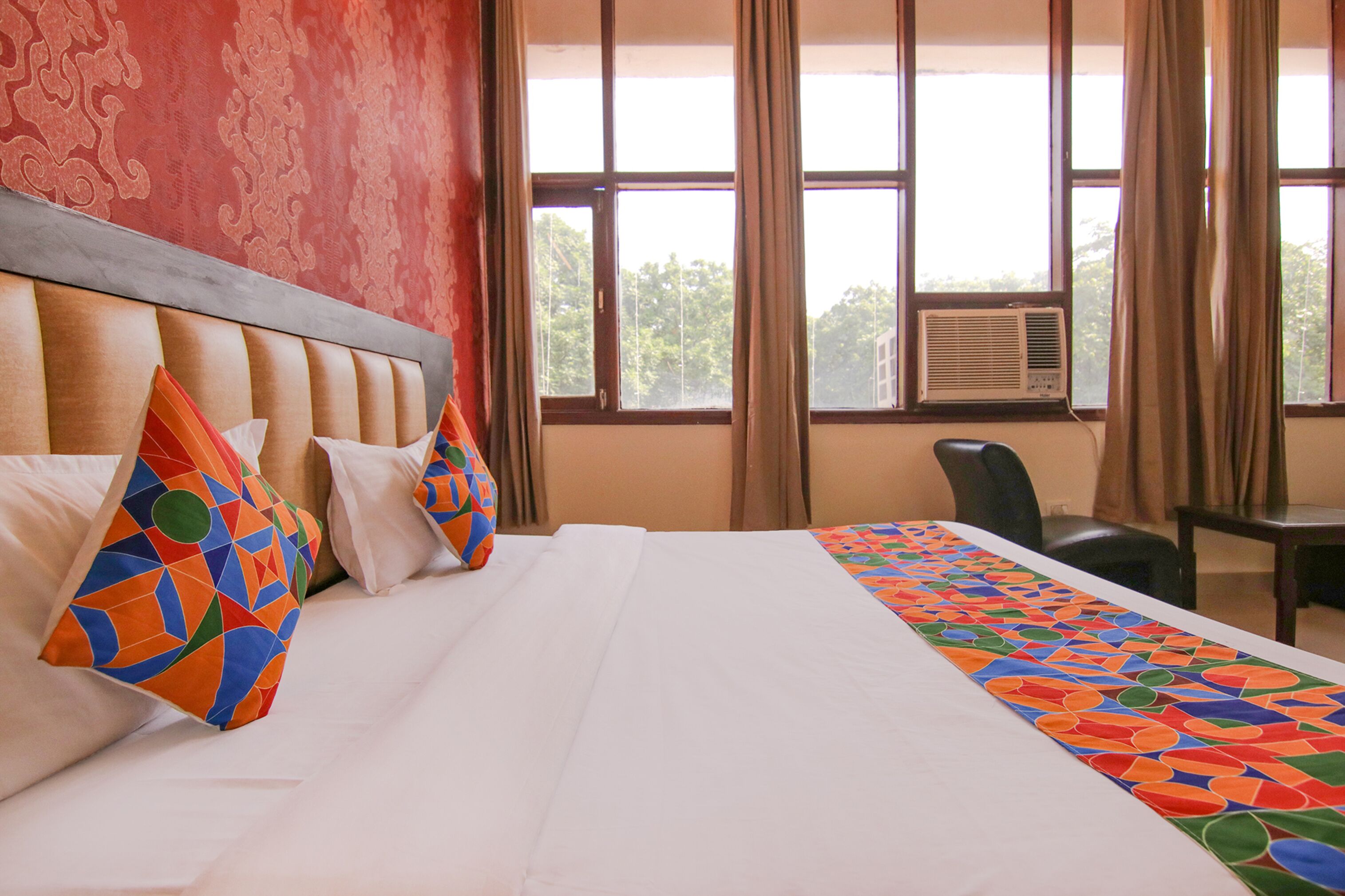 Habitació d'hotel amb un llit gran, un capçal, una taula i una cadira.