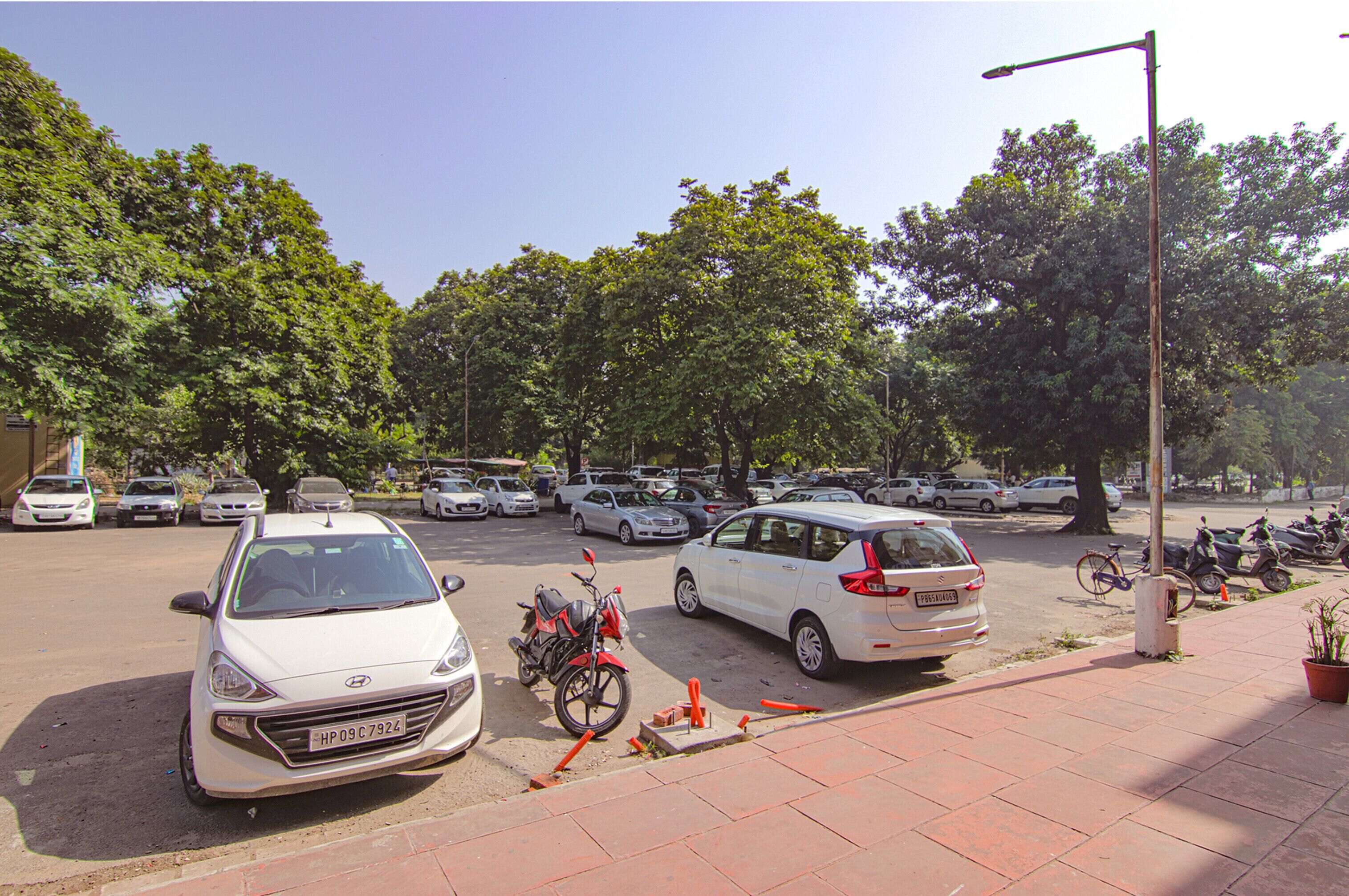 Un estacionamiento con varios coches y algunas motocicletas.