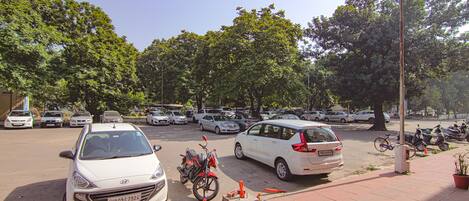 Un estacionamiento con varios coches y algunas motocicletas.
