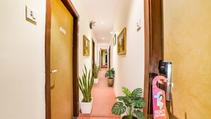 Un couloir d’hôtel avec les portes numérotées 606 et 607, des plantes en pot et une pancarte « Ne pas déranger ».