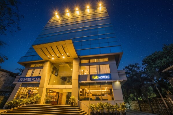 Un hôtel moderne doté d’une façade en verre, d’une entrée bien visible et d’une enseigne « TabHotels ».