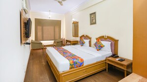 A hotel room with a bed, bedside table, chair, desk, and a ceiling fan. - FabHotel Altus - DLF CyberHub, Gurugram (Gurugram)