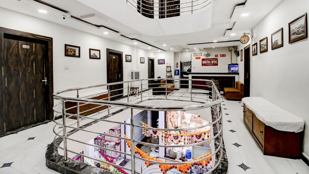 Un hall d’hôtel avec un escalier central, un comptoir d’accueil et un espace salon.