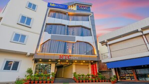 Un hôtel à plusieurs étages doté d’une façade moderne, avec des enseignes indiquant « fabHOTELS » et « HTC City Mall ».