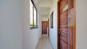 Un couloir avec une porte en bois portant le numéro « 101 » et une fenêtre sur le côté gauche.