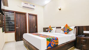 Un dormitorio con cama, mesita de noche, aire acondicionado y armario.