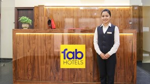 Un mostrador de recepción con detalles de madera y el logotipo de 'fab hotels'.