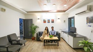 A modern office space with a reception area, a sofa, a coffee table, and a TV. - FabHotel F9 Noida Sector 51 (Noida)