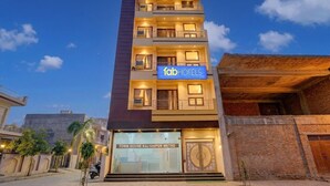 A multi-story hotel with balconies, a sign reading 'fab hotels,' and a ground-level sign for 'TOWN HOUSE KALYANPUR METRO.' - FabHotel Metro Inn (Kanpur)