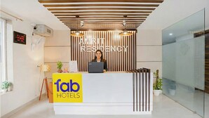 Una mesa de recepción con un cartel que indica 'Amrit Residency' y 'fab hotels'.