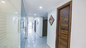 Un pasillo limpio y bien iluminado con un cartel que indica un baño.