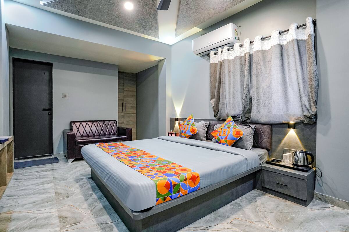 Un dormitorio moderno con cama, mesita de noche y unidad de aire acondicionado.