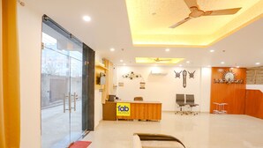 A hotel reception area with a reception desk, chairs, a ceiling fan, and a wall-mounted clock. - FabHotel Taj Residency (New Delhi)