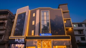 A modern hotel with a prominent facade, large windows, and illuminated signage for 'fabHOTELS' and 'HLUA PORL KIMAWA'. - FabHotel Urban Residency (New Delhi)