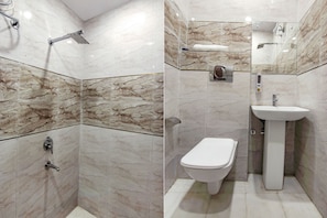 Une salle de bain équipée d’une douche, de toilettes et d’un lavabo, avec des murs en marbre et un miroir.