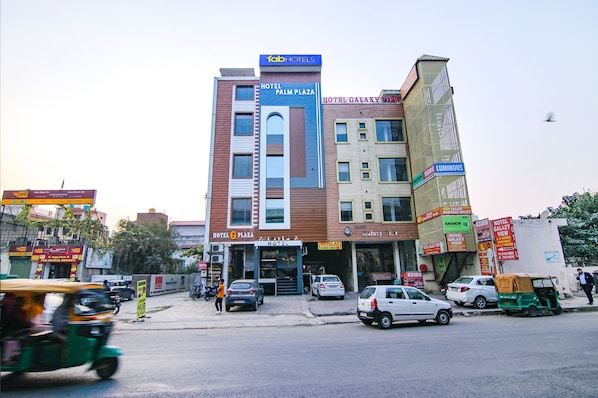 Un immeuble à plusieurs étages, sur lequel on peut voir des enseignes indiquant « Hôtel Palm Plaza » et « Hôtel Galaxy Jewel ».