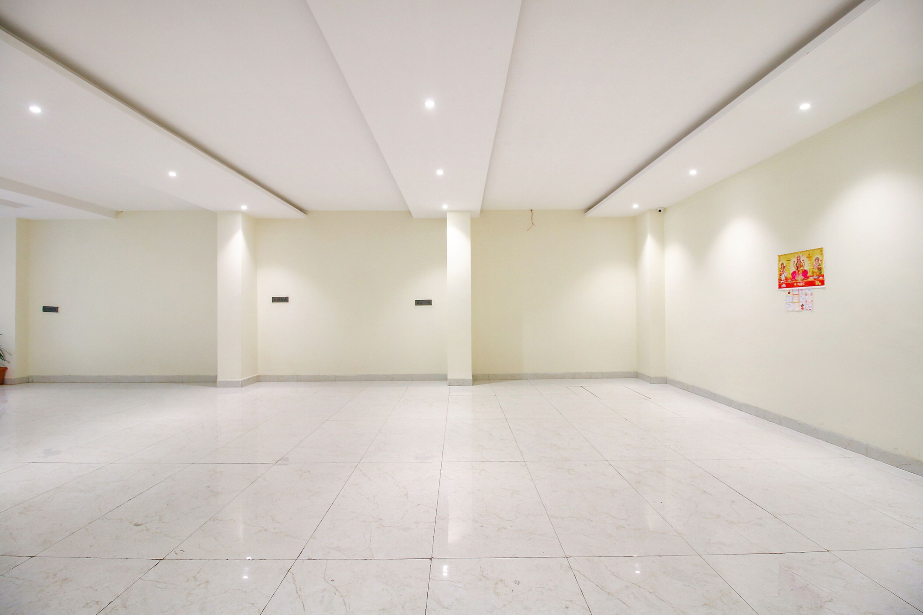 A spacious, well-lit room with a tiled floor and a plain wall.