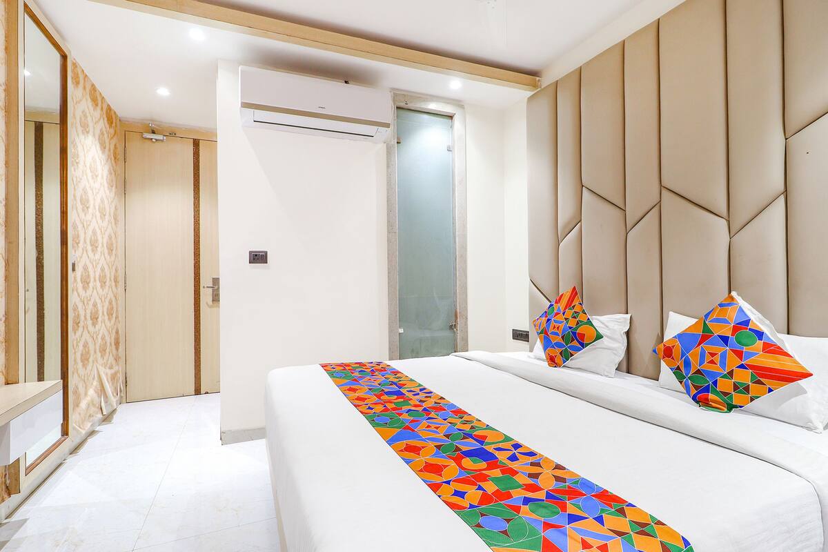Une chambre d’hôtel avec un grand lit, une table de chevet, une armoire et une porte de salle de bain.