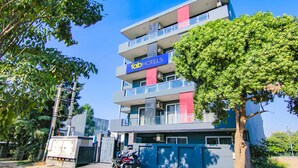 A multi-story hotel with a prominent 'fab hotels' sign, balconies, and a tree in front. - FabHotel Infinity Stays (Gurugram)