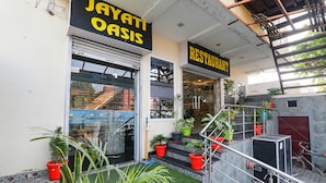 Une devanture de magasin avec une enseigne indiquant « JAYATI OASIS » et « RESTAURANT » au-dessus de l’entrée.