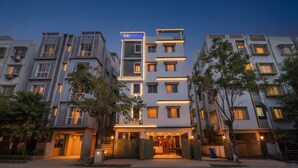 A modern hotel with a prominent sign, multiple floors, and a well-lit entrance. - FabHotel Dreamworld Residency (Barasat)