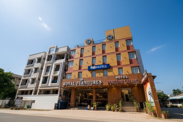 Um hotel com um letreiro para 'Royal Furnitures' e 'Hotel Fortune Grand'.