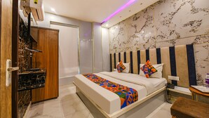A hotel room with a bed, bedside table, and a wooden wardrobe. - Fabhotel The Dreams (Kharar)