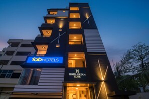 A modern hotel building with a sign for 'fabHOTELS' and 'HOTEL DREAM ELITE'.