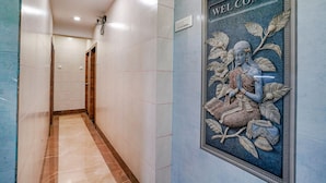 A hallway with a 'WELCOME' sign and a decorative mural. - FabHotel White Gold (Navi Mumbai)