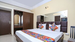 Ein Hotelzimmer mit einem großen Bett, einem Kleiderschrank, einem Spiegel und einem Nachttisch.