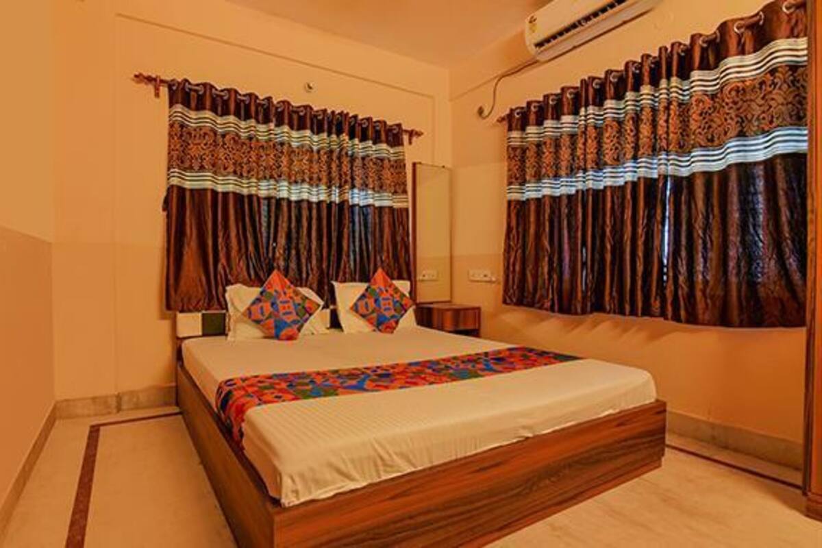 Un dormitorio con una cama grande, cortinas y un equipo de aire acondicionado.