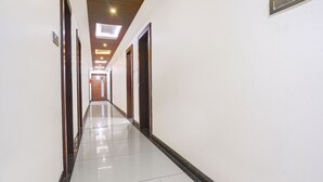 Un passadís llarg i estret amb un sòl polit, sostre de fusta i portes a banda i banda.