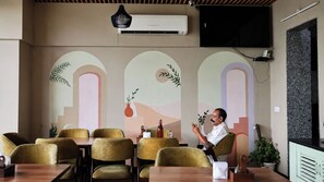 A conference room with a table, chairs, and a person seated. - The White Moon (Jaipur)