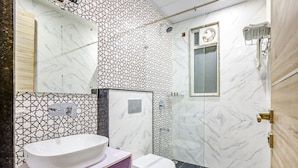 A bathroom with a white sink, a toilet, and a shower area.