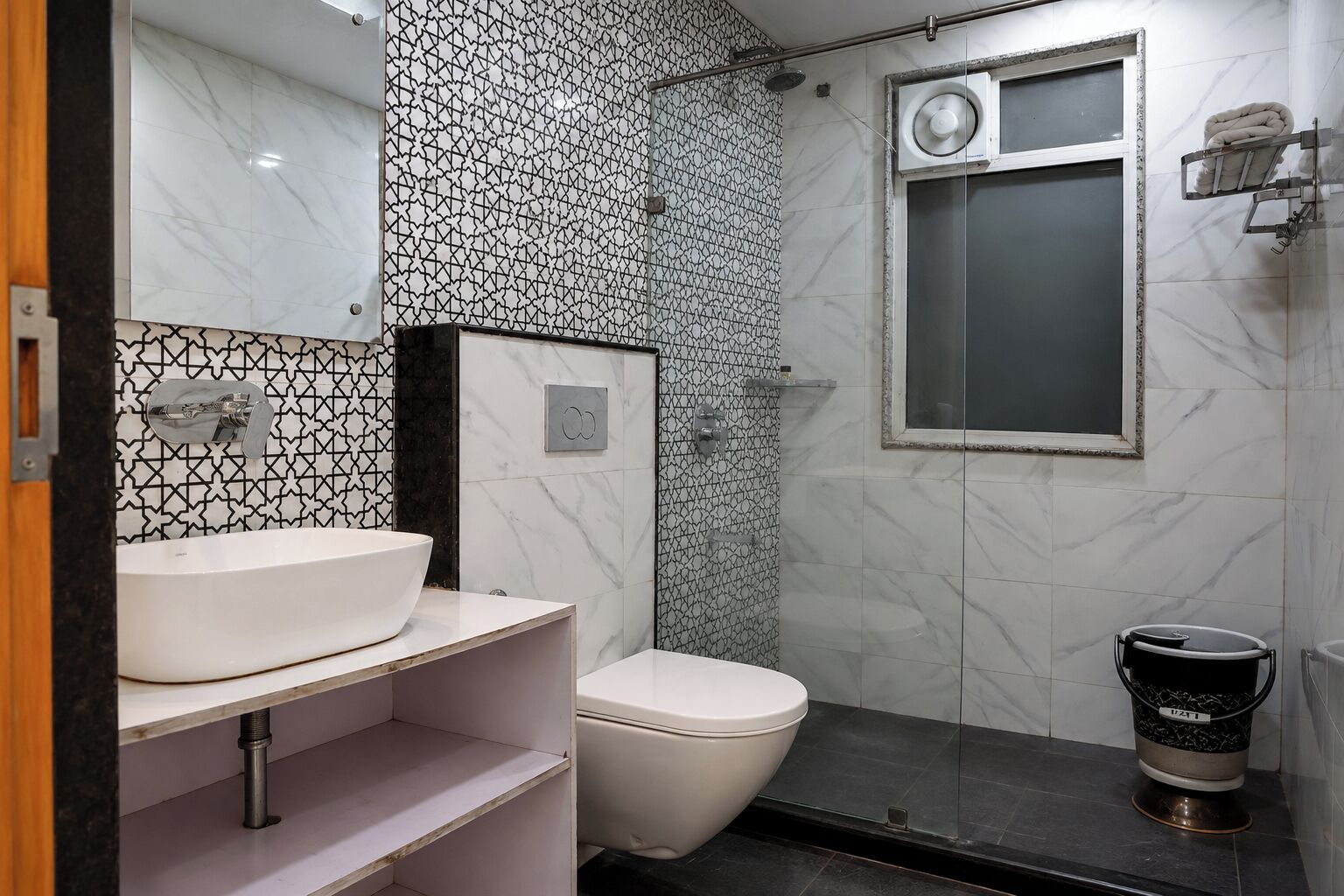A modern bathroom with a white sink, a toilet, and a shower area.