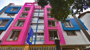 Un edificio de varios pisos con una fachada vibrante, caracterizada por un llamativo esquema de color azul y rosa.