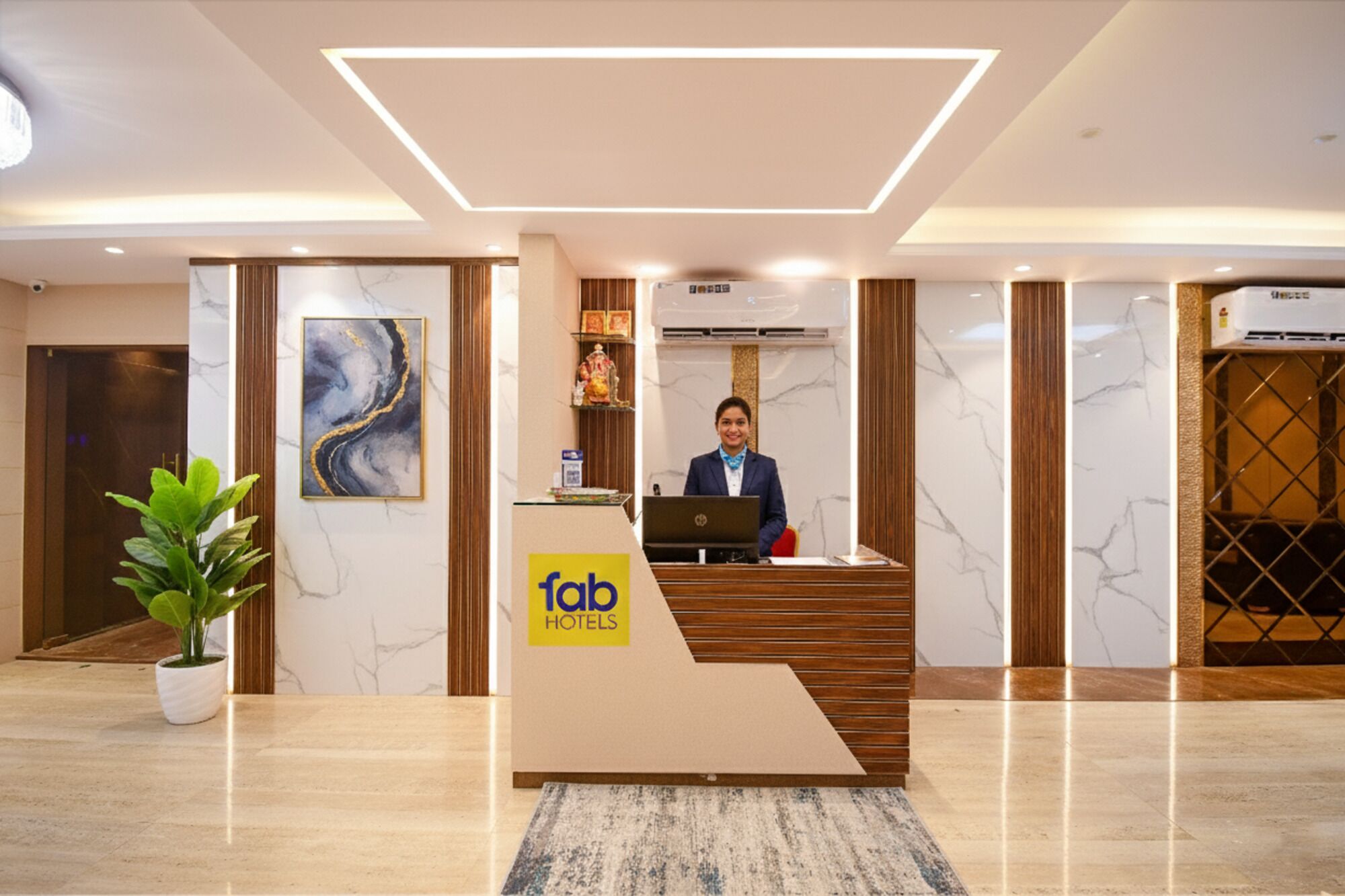 En hotelreception med en receptionist, marmorvægge og et moderne design.