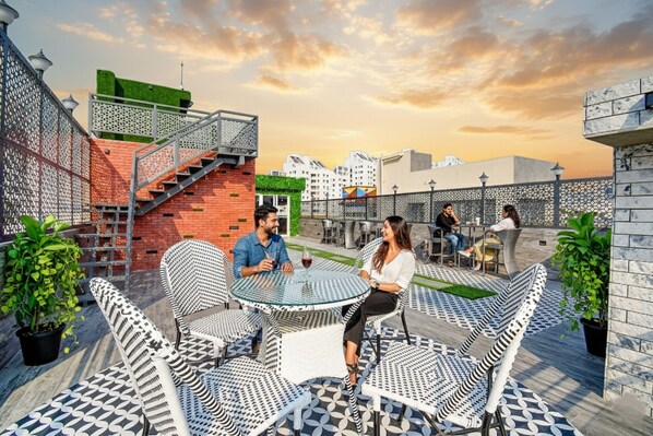 Une terrasse sur le toit, dotée d’un espace extérieur aménagé, d’un escalier et offrant une vue sur le paysage urbain.
