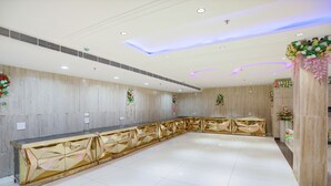 Un amplio vestíbulo de hotel con una larga recepción, paneles decorativos en las paredes y un diseño moderno del techo.