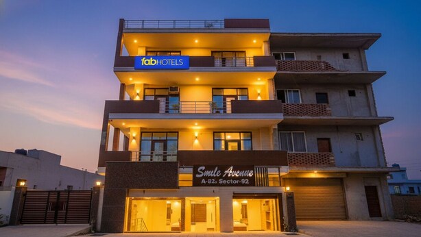 Un hotel de varios pisos con un cartel que dice 'fabHOTELS' y 'Smile Avenue'.