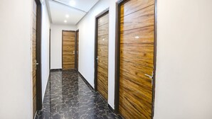 Um corredor com portas de madeira e chão de mármore.