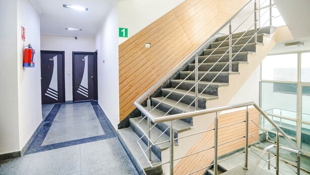 Un couloir d’hôtel moderne avec un escalier menant au deuxième étage.