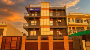 Un immeuble à plusieurs étages, orné d’une enseigne « fabHOTELS », doté de balcons et d’une entrée sécurisée par un portail.