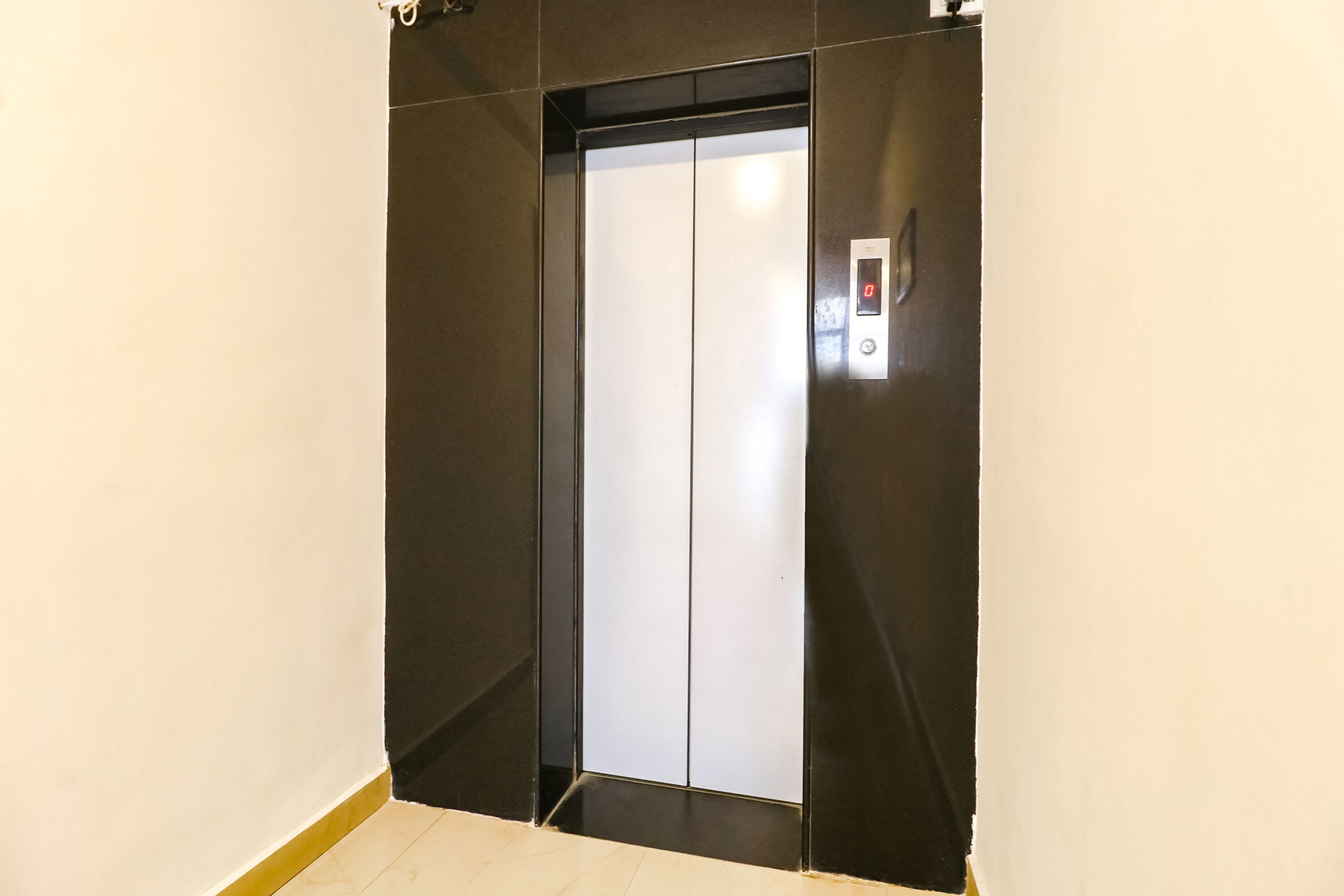 An elevator with a digital display and a metallic door.