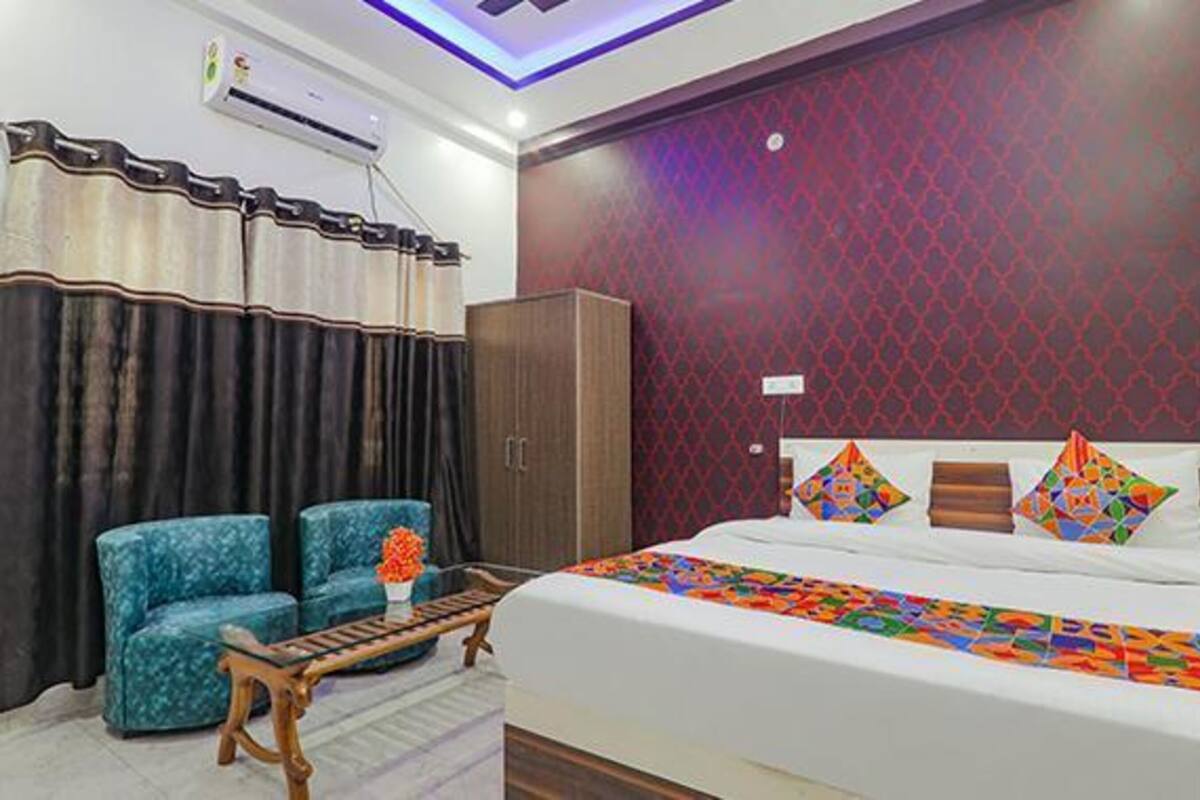Una habitación de hotel con cama, sofá, mesa de madera y armario.
