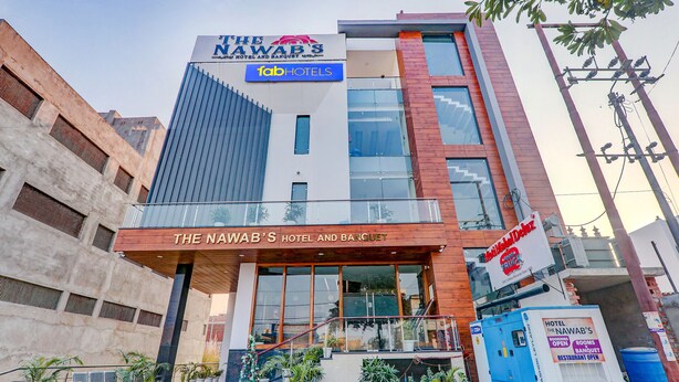 Et moderne hotel med et tydeligt skilt for "The Nawab's Hotel and Banquet" og en "Tab Hotels"-logo.