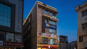 A multi-story building with a 'fabHOTELS' sign, a 'Pizza 6' restaurant, and a 'Party Wall' sign. - FabHotel Pratiksha (Ahmedabad)