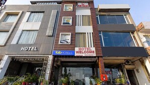 A hotel with a modern facade, a visible entrance, and signage indicating it is a FabHotels property. - FabHotel Welcome Residency (Dera Bassi)